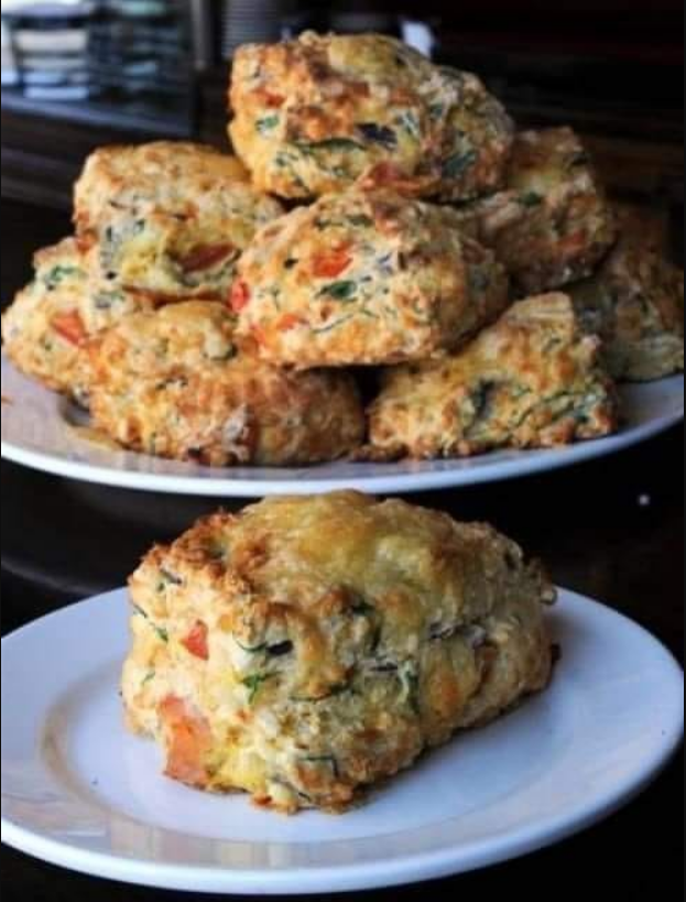 Cheddar and Sun-Dried Tomato Savory Scones: Golden brown scones topped with melted cheddar, sun-dried tomatoes, and green onions.