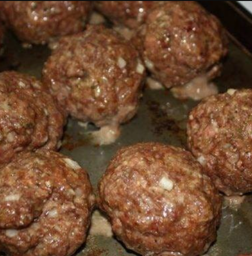 Incredible Baked Meatballs - Golden brown meatballs with a perfect blend of ground beef, Parmesan, and herbs, served with fresh basil.