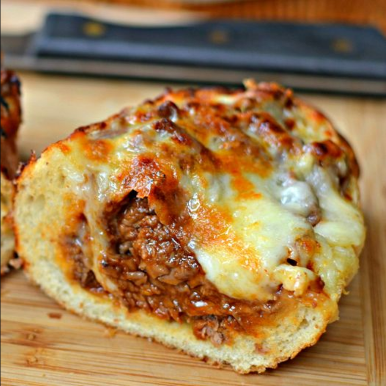 Steak Stuffed French Bread - A golden-crusted French bread boat filled with seasoned steak, topped with melted mozzarella and provolone.