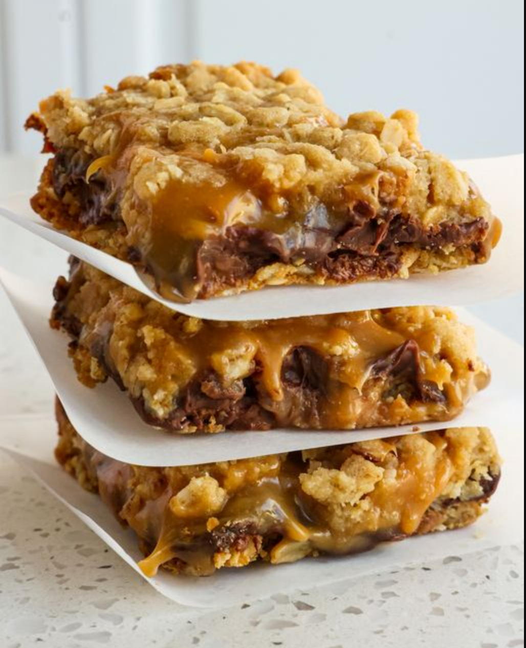 A tray of Easy Carmelitas showcasing layers of oatmeal, chocolate chips, and caramel sauce.