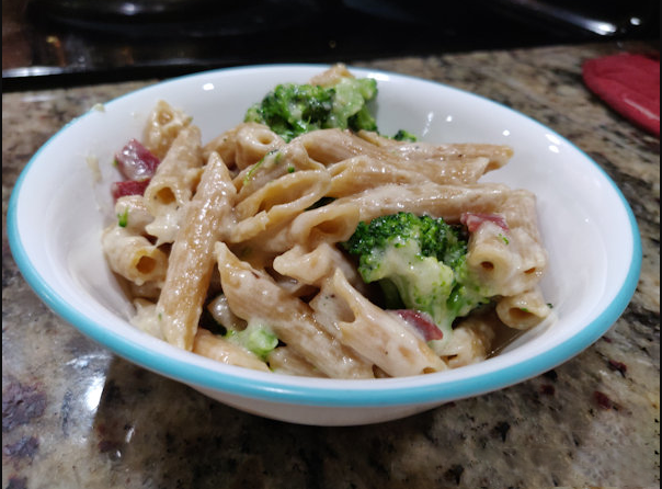 A tantalizing plate of Cheesy Bacon Chicken Pasta adorned with vibrant broccoli florets.