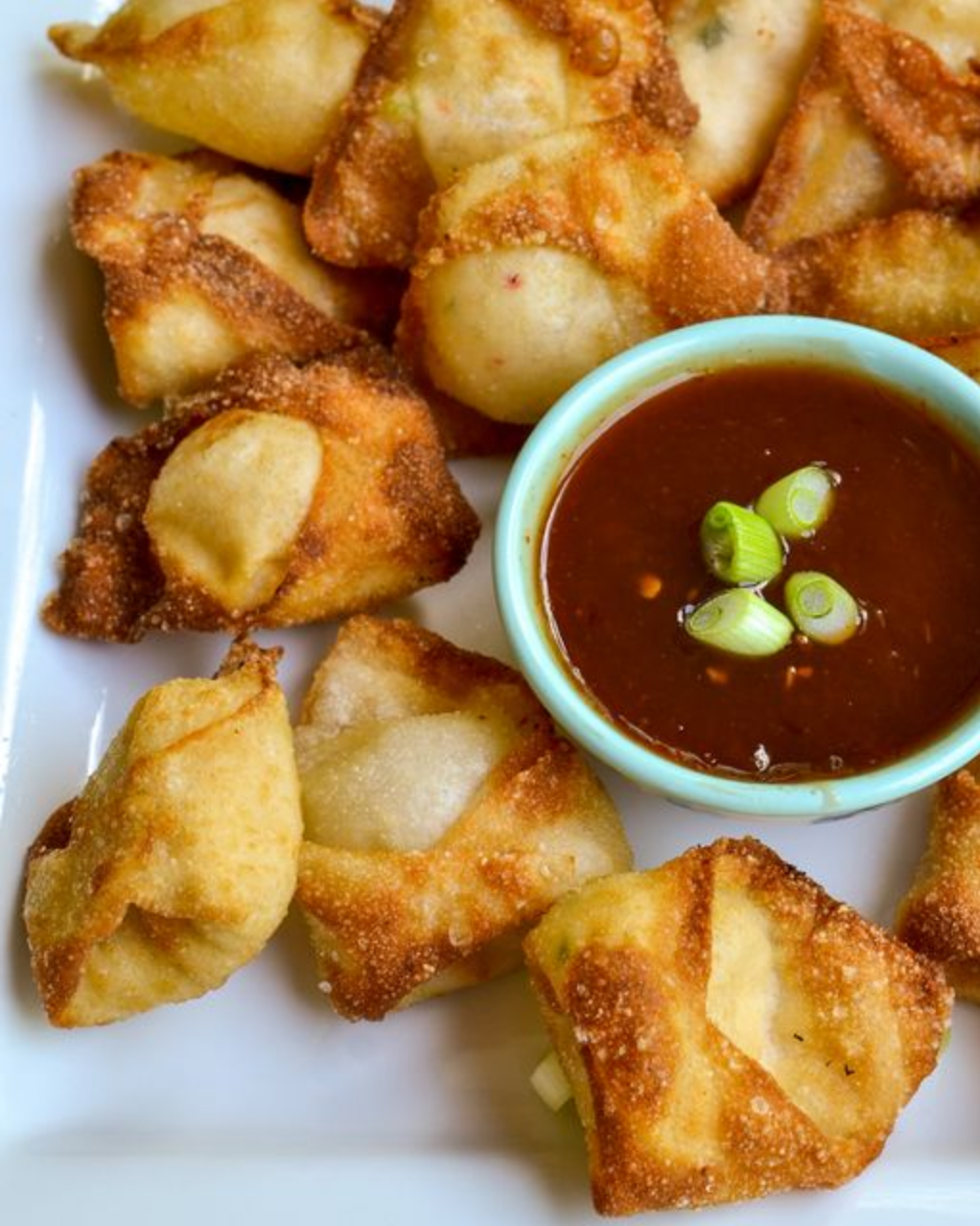 "Crispy Crab Rangoon served on a plate, golden brown and inviting."