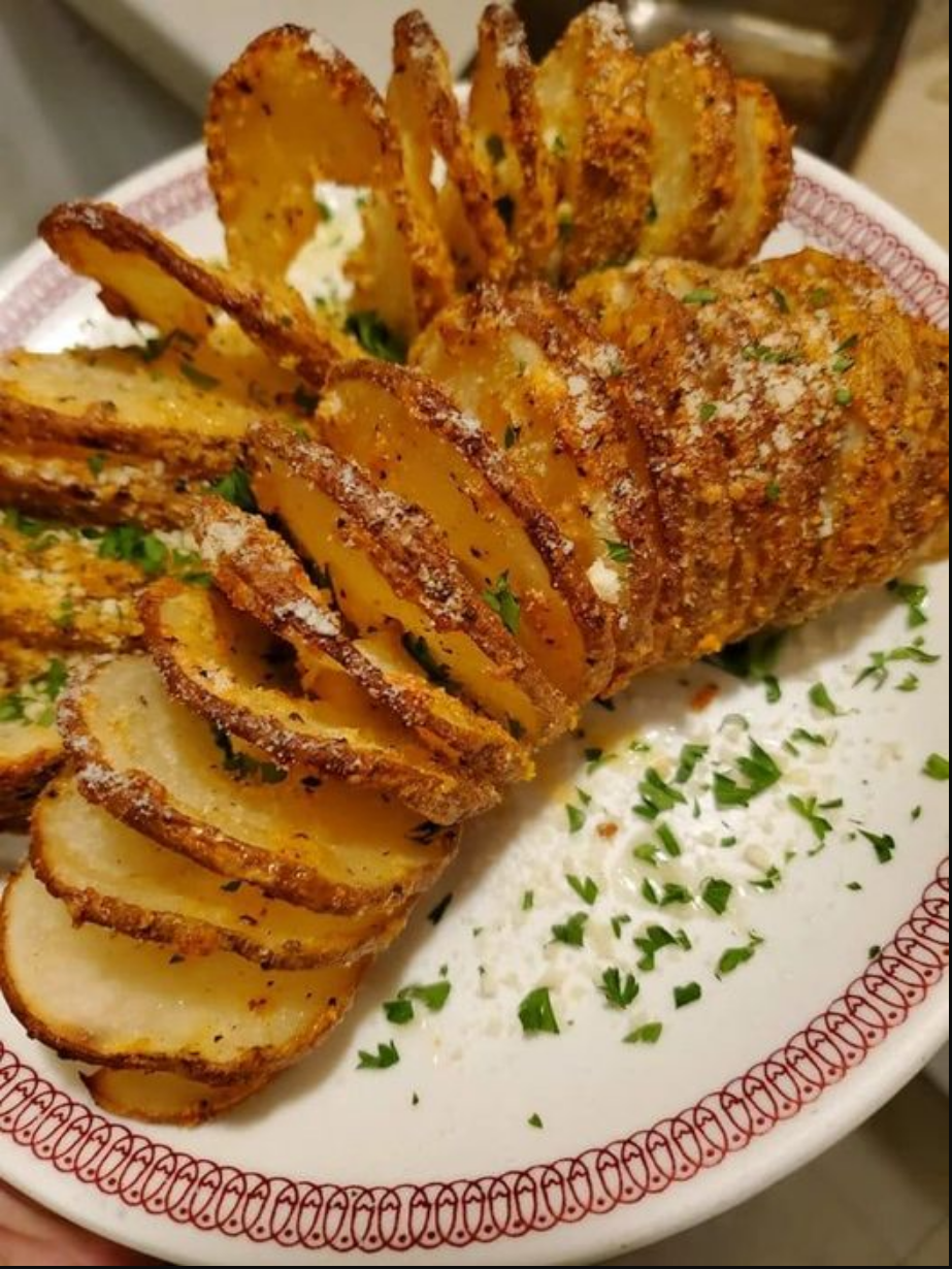 "Sliced Baked Potatoes in a golden hue, sprinkled with Parmesan cheese."