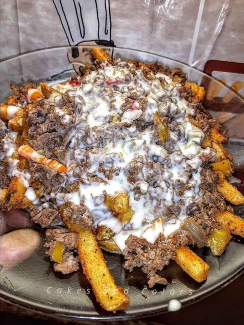 "Philly Steak Cheese Fries piled high with sliced steak, bell peppers, and melted cheddar, drizzled with cheese sauce."