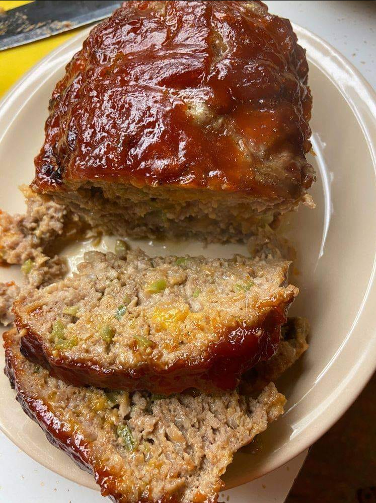 "Delicious homemade meatloaf with a golden crust, served with mashed potatoes and green beans."