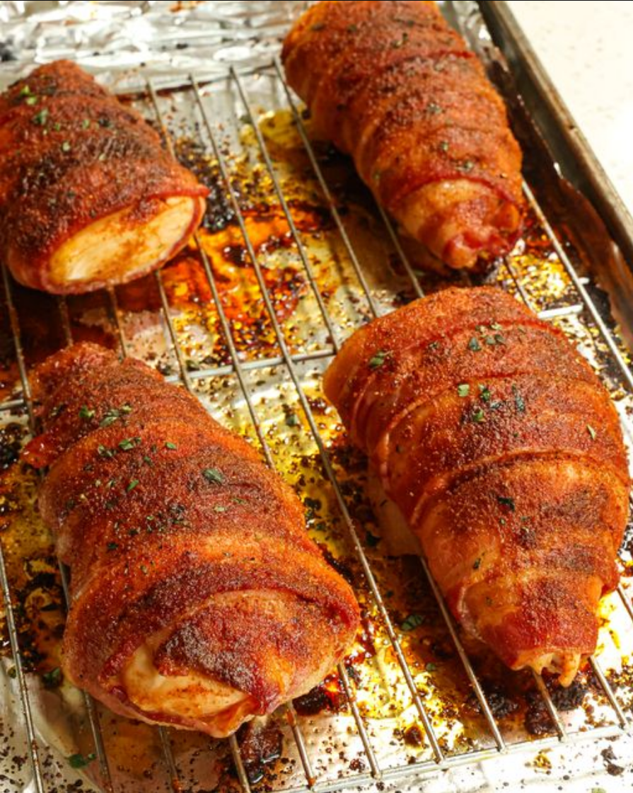 "Bacon-wrapped chicken breasts, golden brown and adorned with fresh herbs."