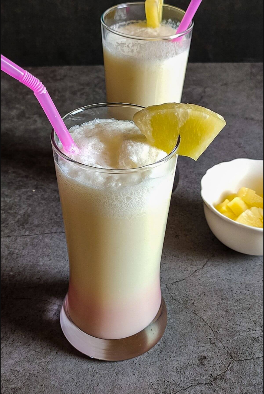 Piña Colada - A refreshing tropical cocktail with pineapple, coconut cream, and a hint of rum, garnished with pineapple slices and coconut flakes.