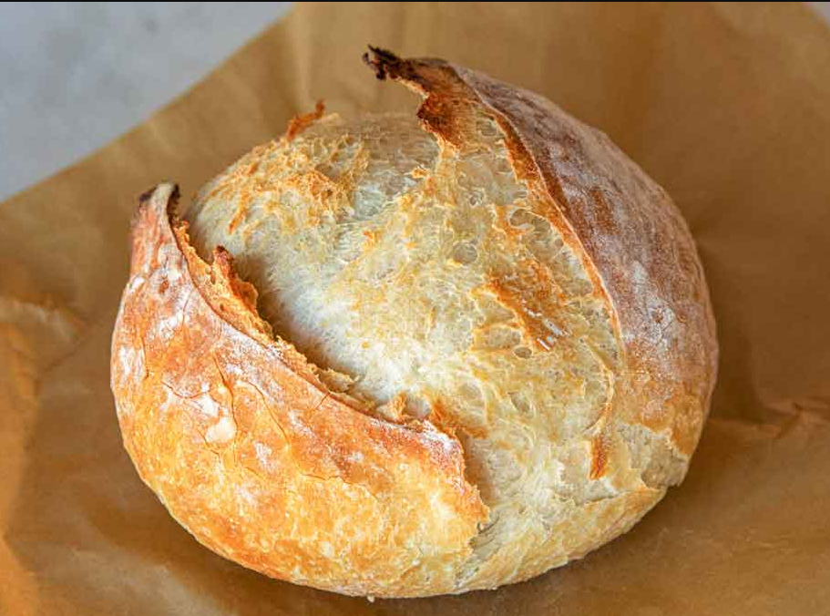 Artisan Bread - A golden-brown loaf with a crispy crust, freshly baked and cooling on a wire rack.