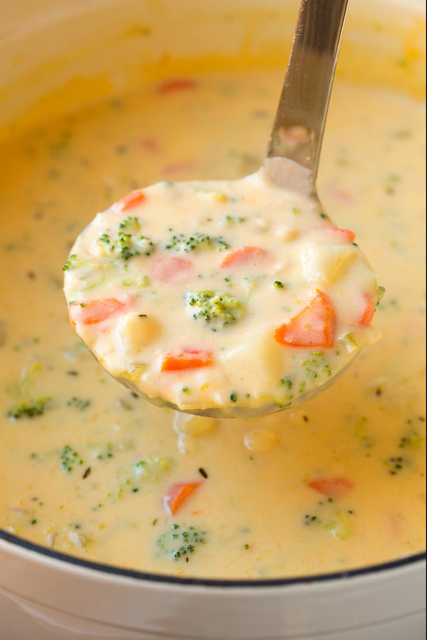 Creamy Potato Broccoli Cheddar Soup - A bowl of velvety soup garnished with broccoli florets and a sprinkle of cheddar cheese.