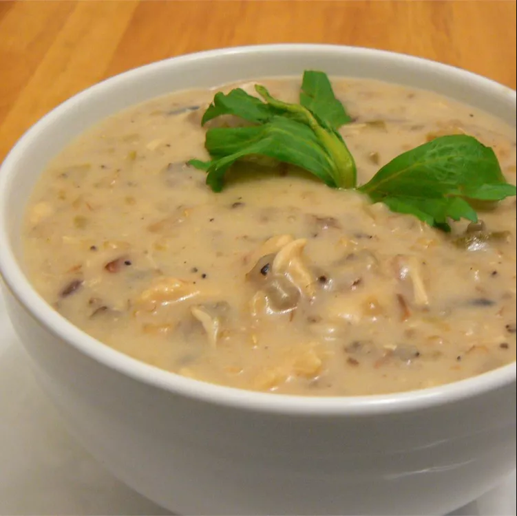 Bowl of Chicken and Wild Rice Soup with fresh herbs garnish