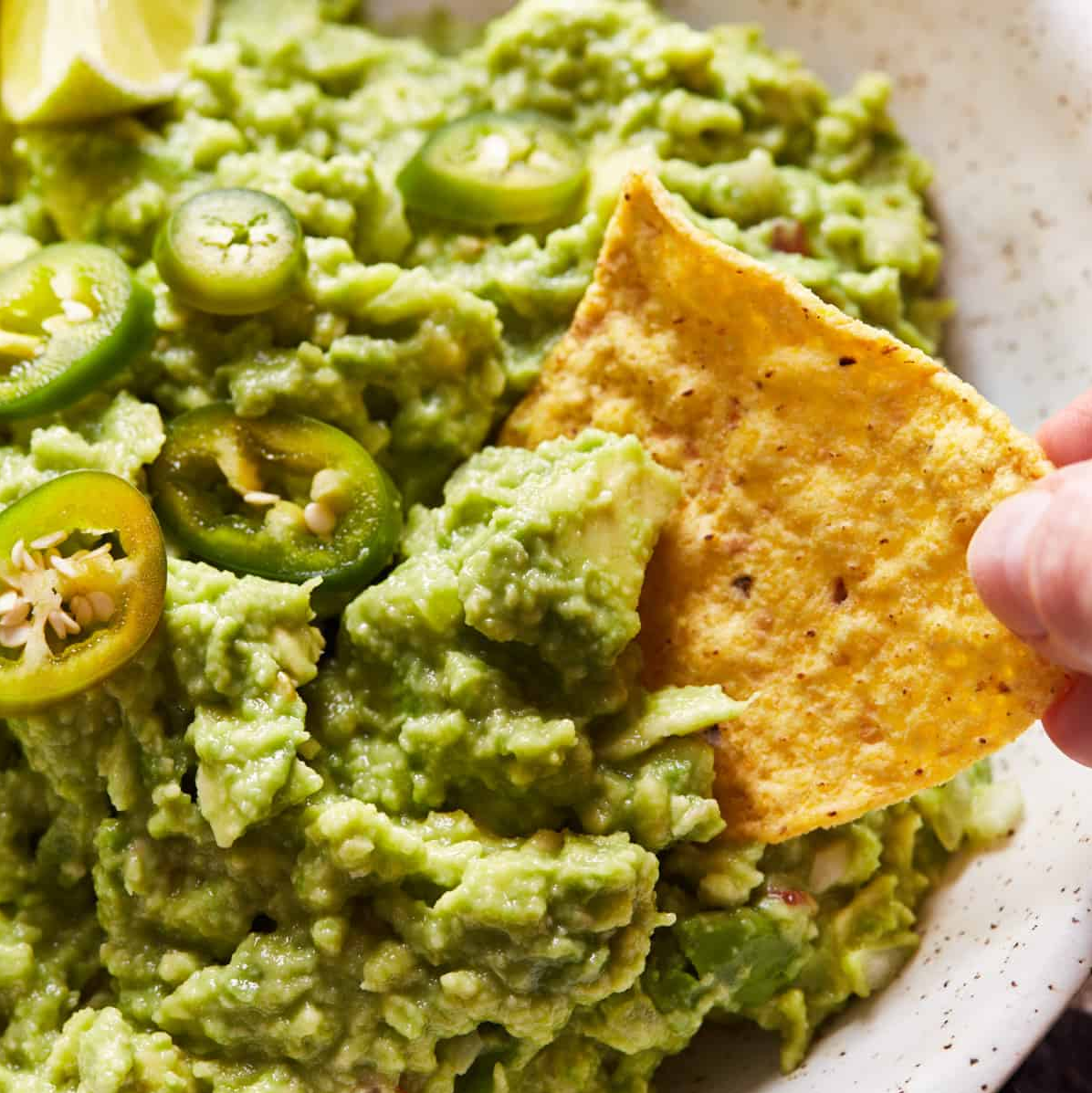 Chunky Guacamole – A vibrant bowl of homemade guacamole with diced tomatoes, cilantro, and lime, served with tortilla chips.