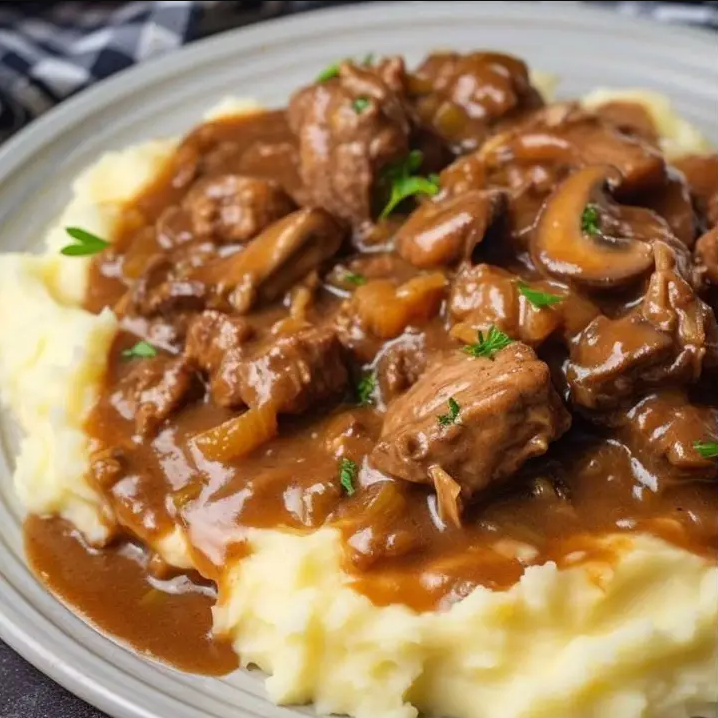 Beef Tips with Mushroom Gravy – Succulent beef bites in a flavorful mushroom-infused sauce, garnished with fresh parsley.